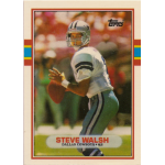 steve walsh 1989 topps rc Football player in action on a trading card, wearing white and blue uniform, holding a football ready to throw.